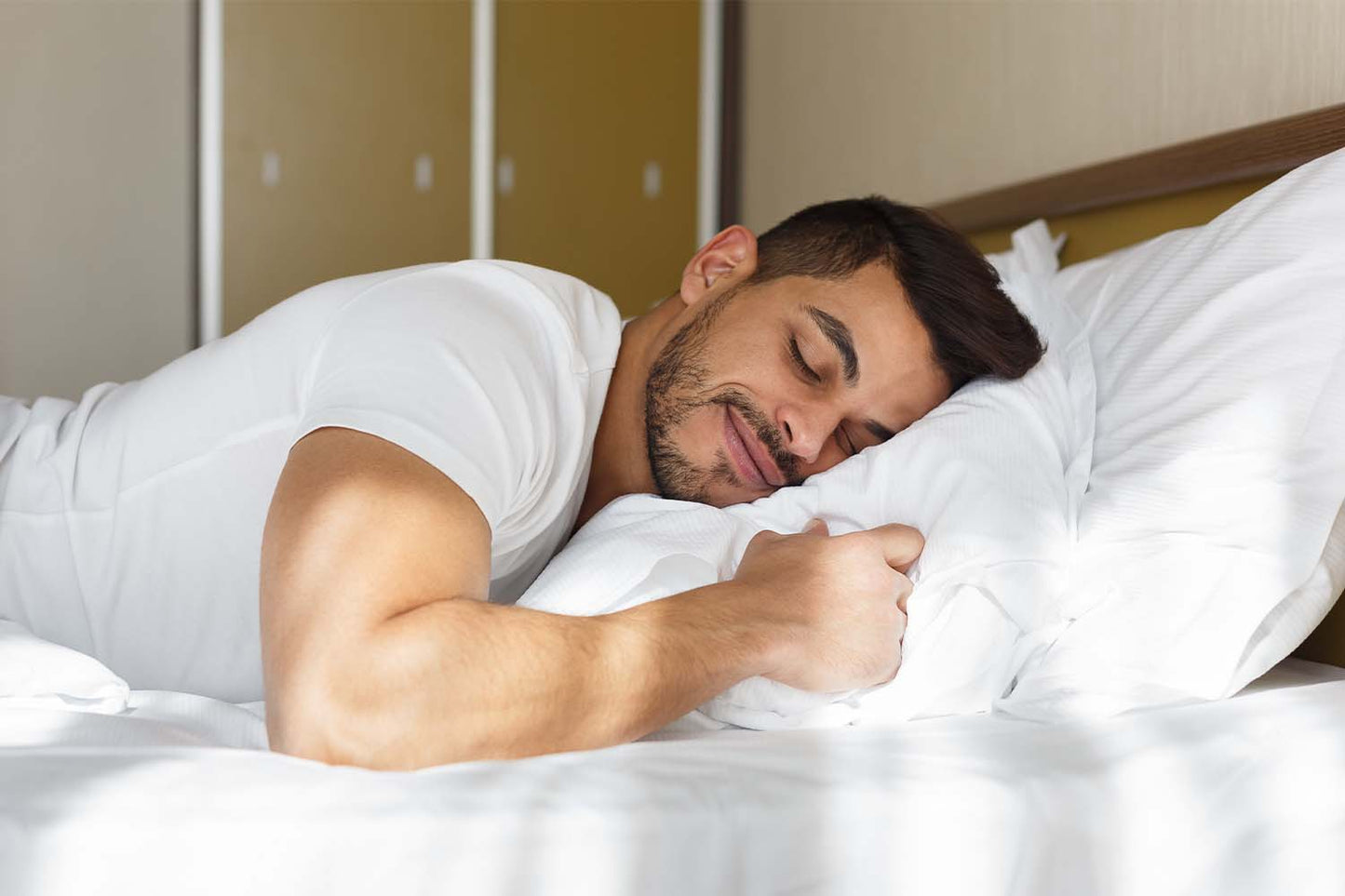 Man lying in bed while receiving a prostate massage.