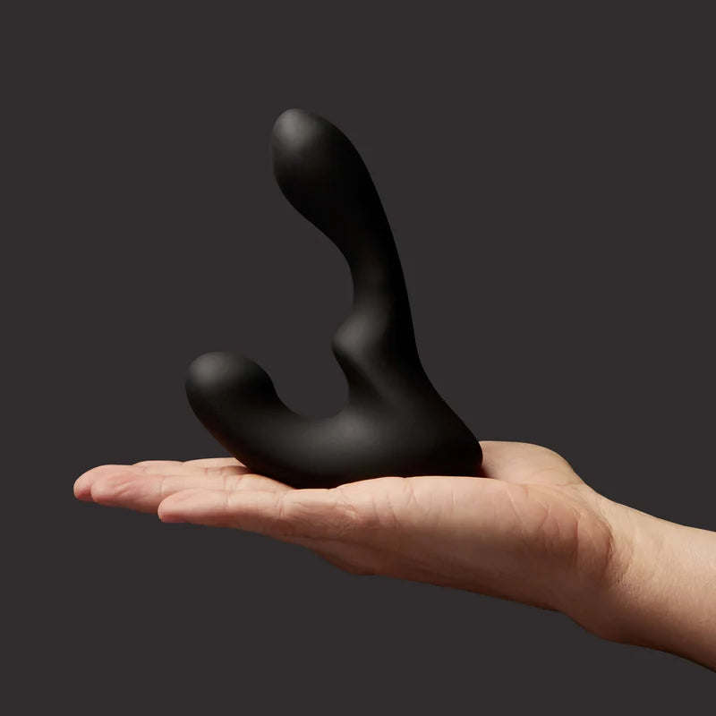 giddi tomo  massager held in a hand against a dark background
