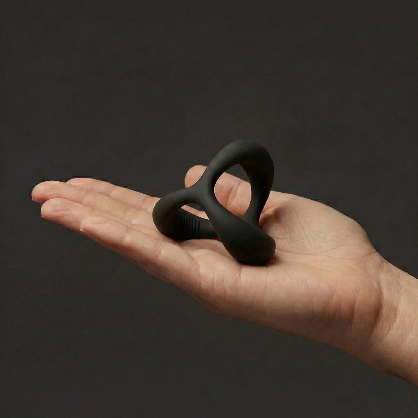 Hand holding black Giddi Cerus tri-ring silicone cock ring sex toy