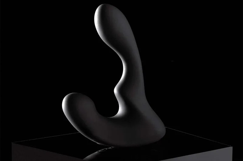 Mygiddi prostate massager on a black platform with a dark background