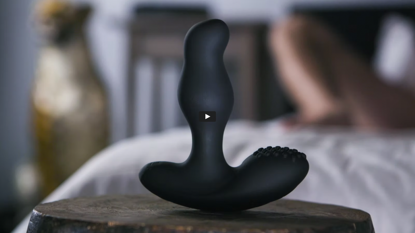 video thumbnail for giddi thor rotating prostate massager; shows thor standing on pedestal in foreground with bedroom out of focus in background